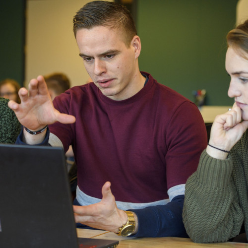 Drie mensen achter laptop