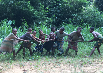 Bayaka women and children playing by pulling on sticks