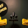 Twee stoelen bij een microfoon met het logo van SURF Sounds
