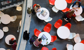 studenten zijn aan het werk op rode stoelen aan witte tafels