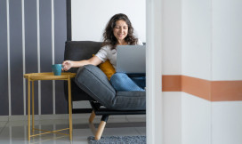 Vrouw achter laptop op de bank