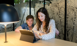 Twee studenten kijken naar het scherm van een tablet