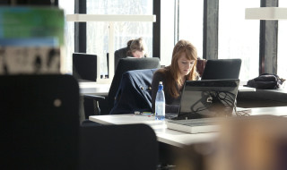 Studente in bibliotheek met computer online 