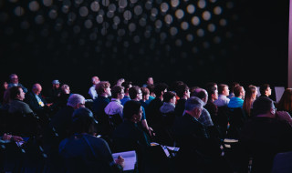 Mensen in een grote zaal op een conferentie