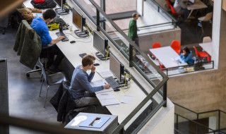 Student achter een computer in een auditorium