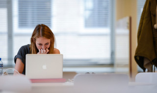 Studente kijkt naar het beeldscherm van een laptop