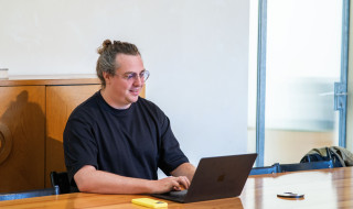 Bob van Luijt zit aan tafel en werkt op zijn laptop. 