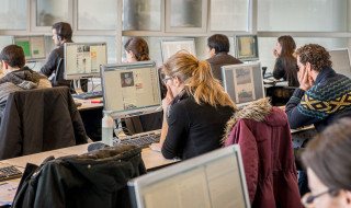 Studenten in theateropstelling achter beeldschermen