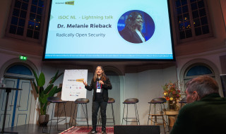 Melanie Rieback geeft presentatie op een podium