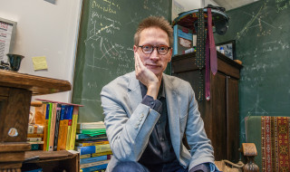 Bob Planqué in zijn werkkamer, je ziet boeken en schoolborden met wiskundige formules