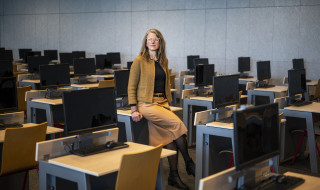Nolda in de Aletta Jacobszaal van de RUG waar digitaal wordt getoetst, het staat vol met tafels en beeldschermen