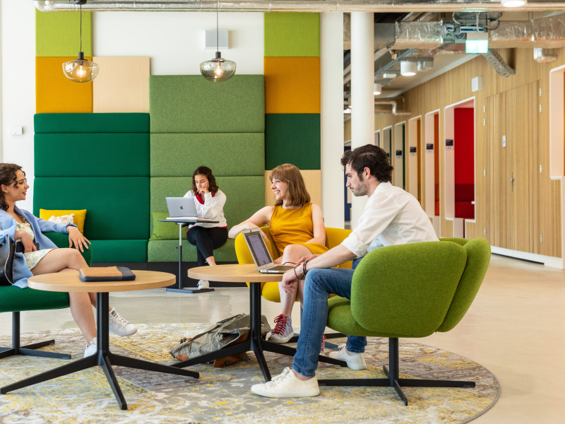 Vier studenten in zitje in de bibliotheek