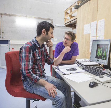 Twee onderzoekers samen achter computer kijken naar data